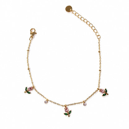 Bracciale Rugiada dorato in acciaio inox con charm floreali rosa, foglie verdi e piccoli cristalli luminosi