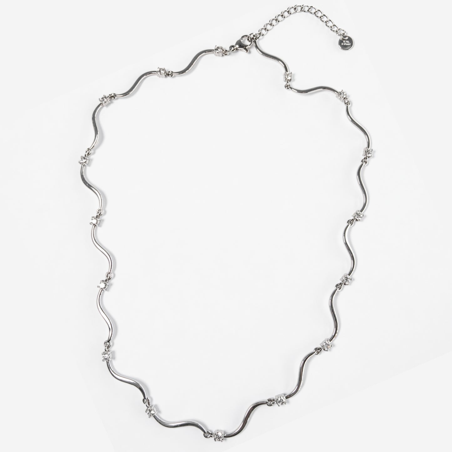 Collana Elettra in acciaio inox con design ondulato e punti luce su sfondo chiaro