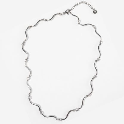 Collana Elettra in acciaio inox con design ondulato e punti luce su sfondo chiaro